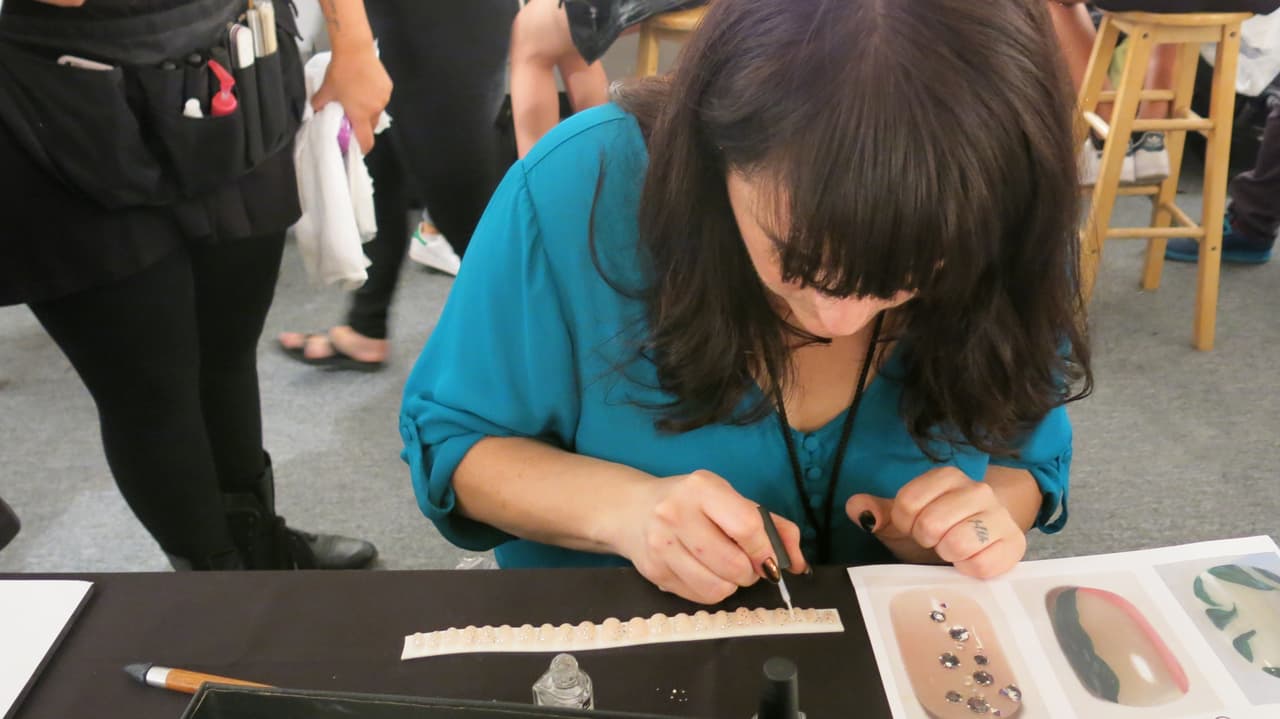 El diseño más lujoso tiene aplicaciones de cristales. Las uñas son vibrantes y van a la perfección con los diseños de los estampados de 
<a href="https://www.aliceandolivia.com/">Alice and Olivia</a>. Las tres propuestas son muy fáciles de llevar.