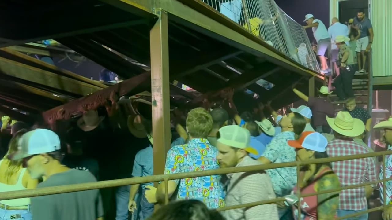 Varios asistentes intentan sostener una parte de las gradas del rodeo en la Feria del Condado de Kendall, Texas, después de que colapsara.