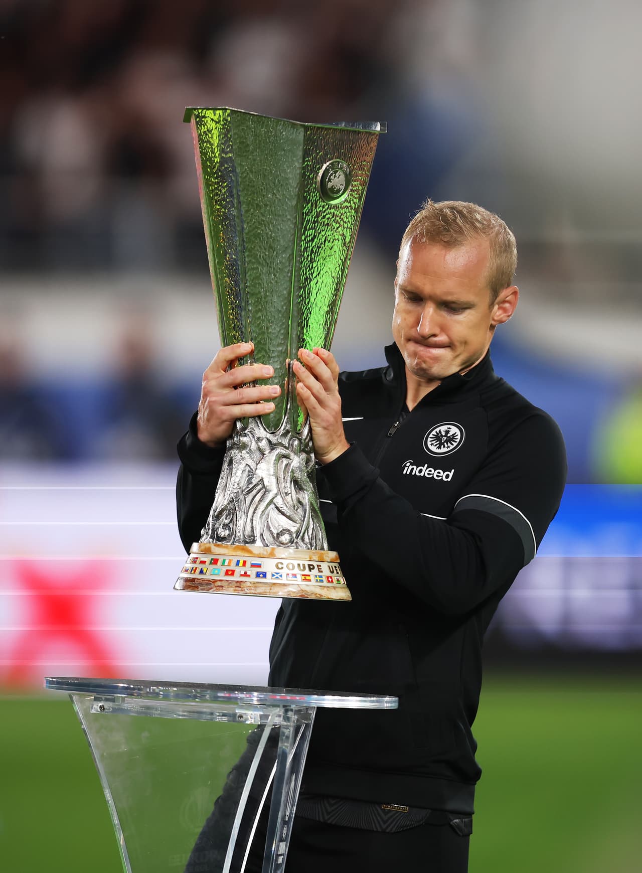 La gente de la entrada colocaba con delicadeza la copa de la Europa League.
<br>