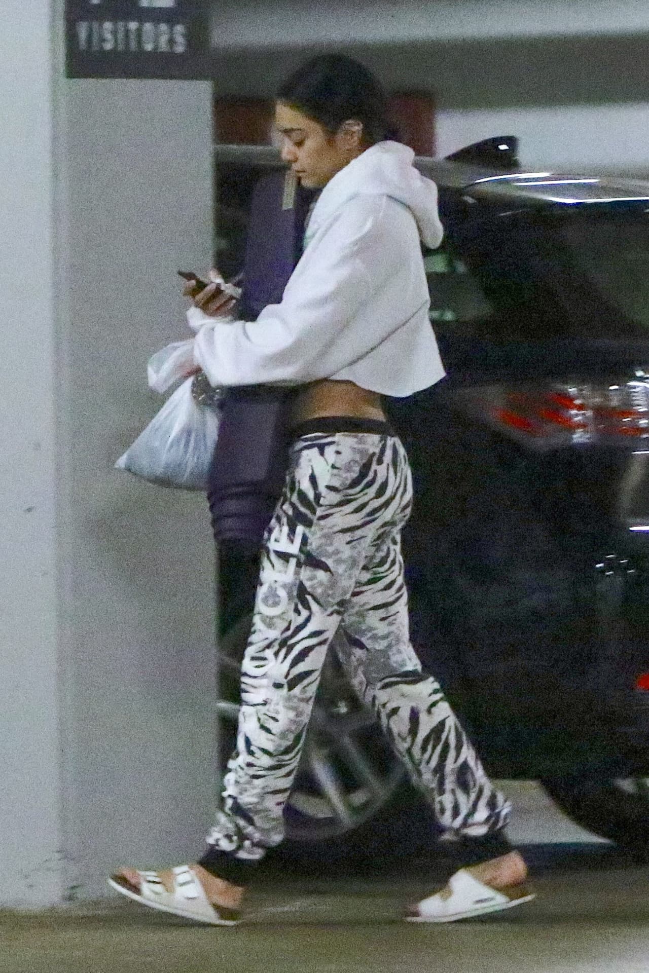 Cabizbaja y sólo prestando atención a su teléfono.