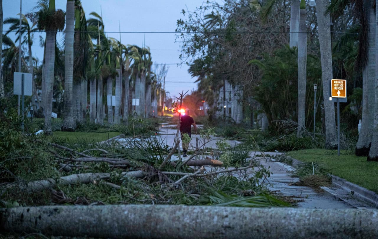 Un hombre camina entre los escombros en una calle de Punta Gorda, Florida.