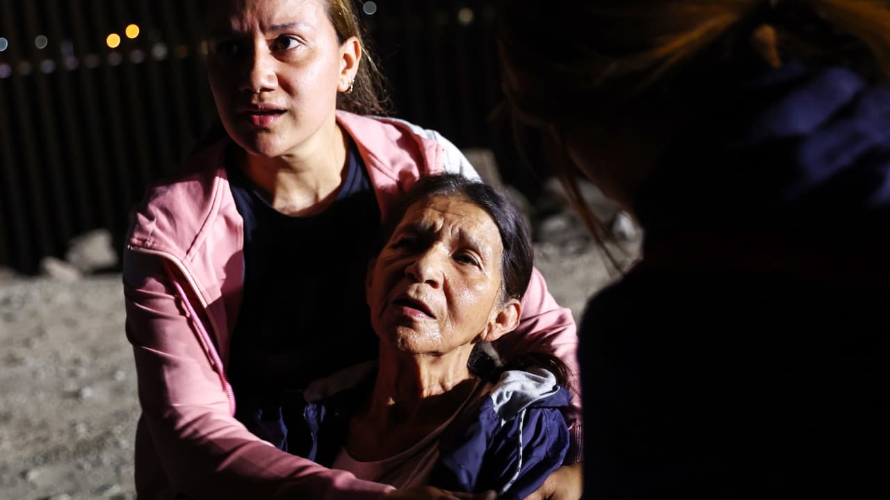 Los inmigrantes descansan y reaccionan poco después de cruzar una brecha en la valla fronteriza entre Estados Unidos y México antes de ser procesados por la Patrulla Fronteriza de Estados Unidos.