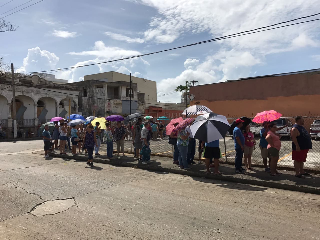 Residentes de Mayagüez hacen fila en la Funeraria Fernández, donde tienen un teléfono que funciona y se lo han habilitado a los residentes para que se comuniquen con sus seres queridos.