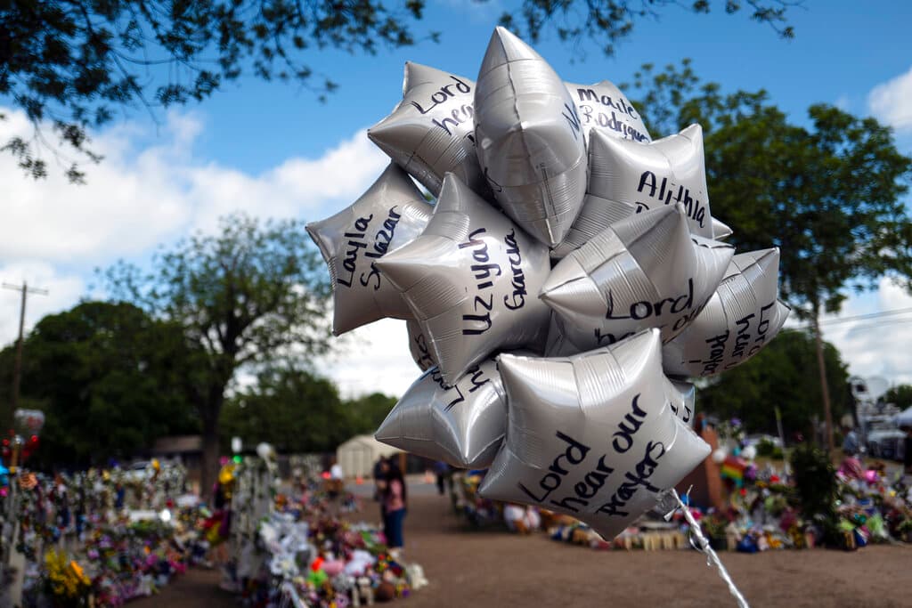 Globos en honor a las víctimas del tiroteo escolar de la semana pasada se balancean con el viento.