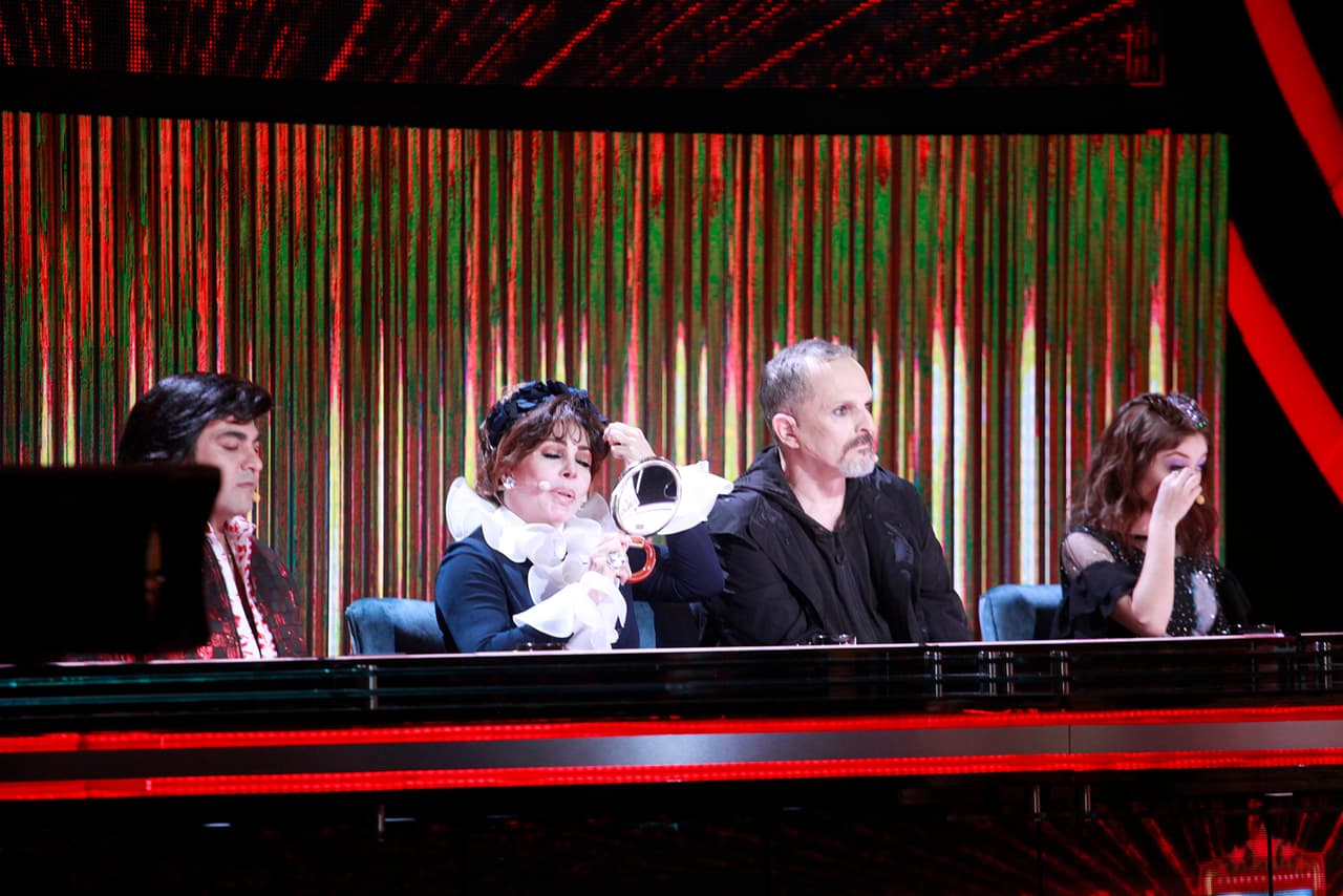 Su pelo recogido, decorado con un tocado floral azul marino, complementaba el look.