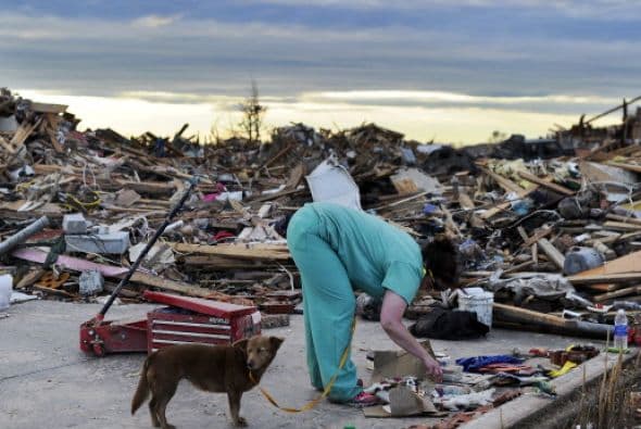 Los sobrevivientes al tornado recuperan sus recuerdos entre los escombros.