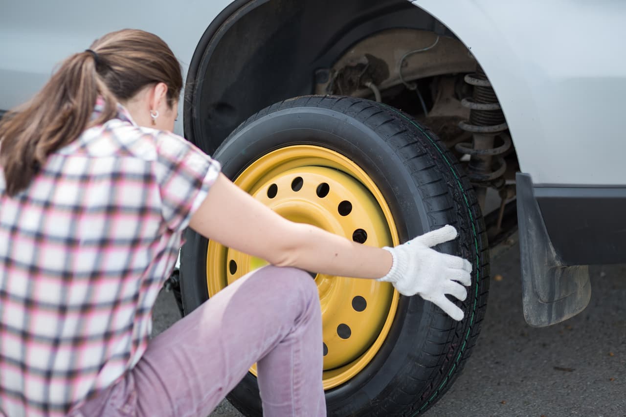 13. 
<b>Instala el neumático de repuesto</b>.
<br>
<br>Alinea los orificios del rin con los pernos que sobresalen de la base y empuja la rueda hasta que toque fondo.