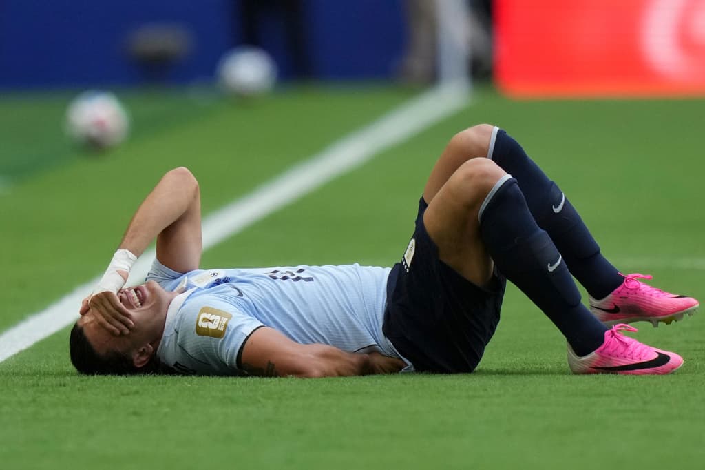 Agustín Canobbio, de Uruguay, yace en el suelo durante el partido de fútbol.