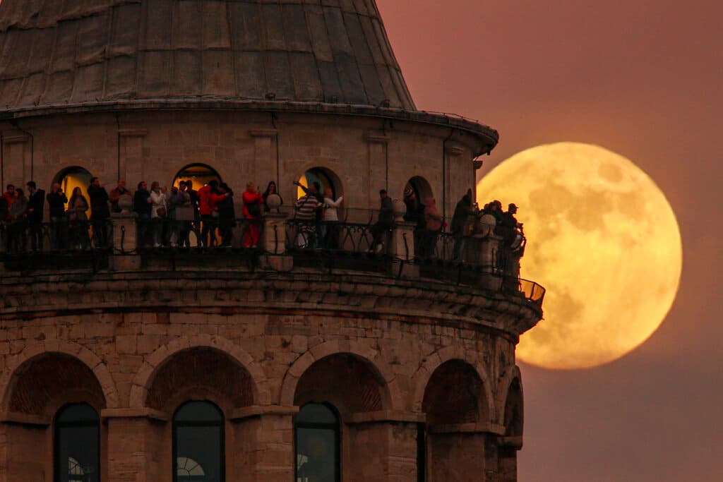 La última luna llena del año, en la imagen detrás de la torre Gálata en Estambul, también se conoce como la de la "larga noche" porque es la más cercana al solsticio de invierno.