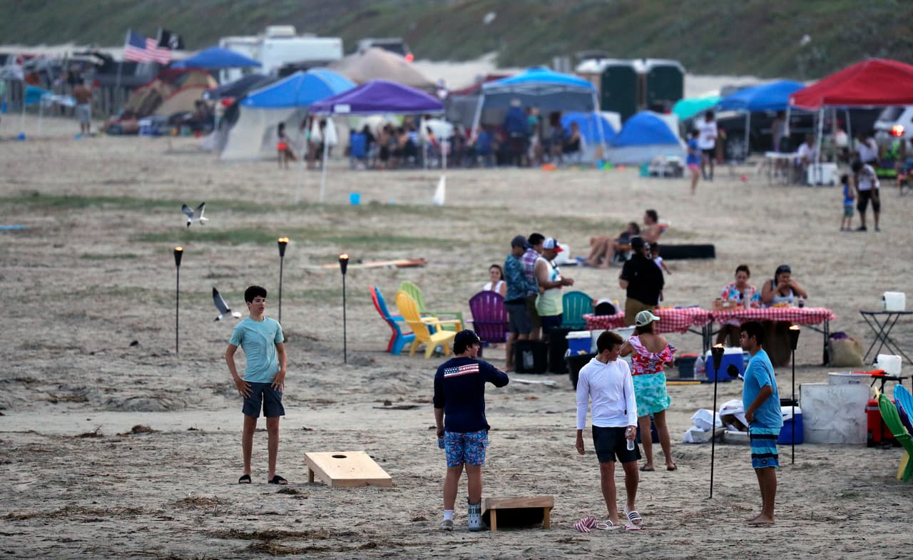 Cientos de personas disfrutan de la playa el sábado 23 de mayo de 2020, en el fin de semana feriado por el Día de los Caídos en las Guerras, en Port Aransas, Texas, en medio de la pandemia del coronavirus. (AP Foto/Eric Gay)