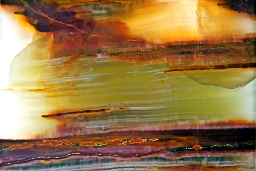 Esta roca calcárea está compuesta por bandas múltiples que pueden variar de textura y color, desde el blanco hasta casi cualquier color excepto algunos tonos de azul y morado. Las más frecuentes son las piedras ónix de color blanco, rojo, amarillo pero sobre todo, negro.