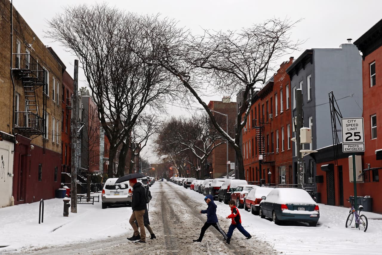 Un grupo de personas cruza una calle nevada en el barrio de Carroll Gardens, en Brooklyn.