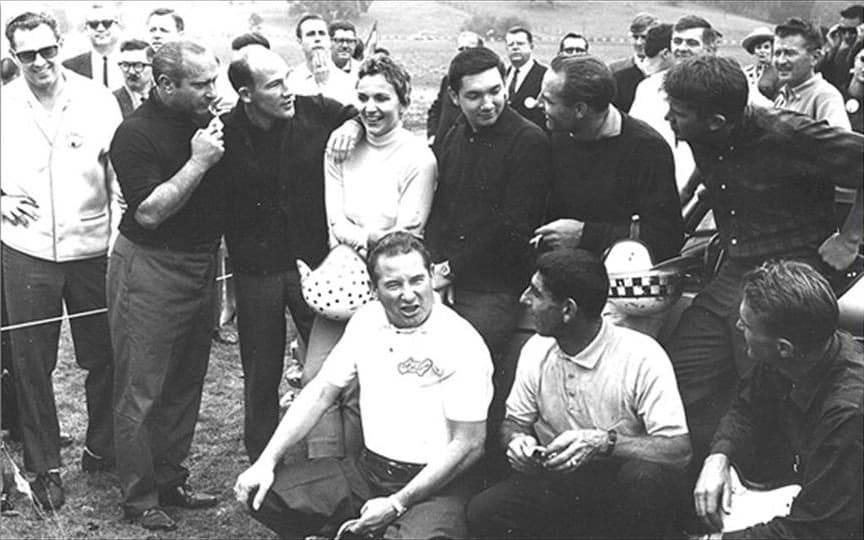 <h3 class="cms-H3-H3"><b>Denise McCluggage</b></h3>
<br>
<br>Fue una corredora de autos que se codeaba de tú a tú con los grandes del automovilismo mundial como Fangio o Stirling Moss, con quienes se le ve en la imagen, sino que también fue una excelente periodista automotriz. McCluggage escribió por décadas una influyente columna en el diario automotriz Autoweek.
<br>
<br>En 1961 ganó el primer lugar en la categoría GT de las 12 Horas de Sebring logrando el 10 lugar total entre todas las categorías y ese mismo año ganó la Copa de Damas en el
<b>Gran Premio de Venezuela</b> a bordo de su querido
<b>Porsche 550</b>. Una de sus más grandes proezas fue lograr el primer lugar en su clase en el Rally de Monte Carlo de 1964 a bordo de un Ford Falcon.