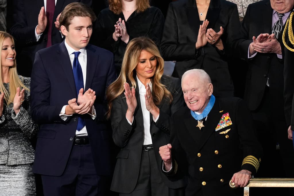 Barron Trump y la primera dama Melania Trump aplauden al capitán Royce Williams, piloto de la Armada durante la Segunda Guerra Mundial, durante el discurso sobre el estado de la Unión del presidente Donald Trump ante una sesión conjunta del Congreso en la Cámara de Representantes del Capitolio de los Estados Unidos en Washington, el martes 24 de febrero de 2026.