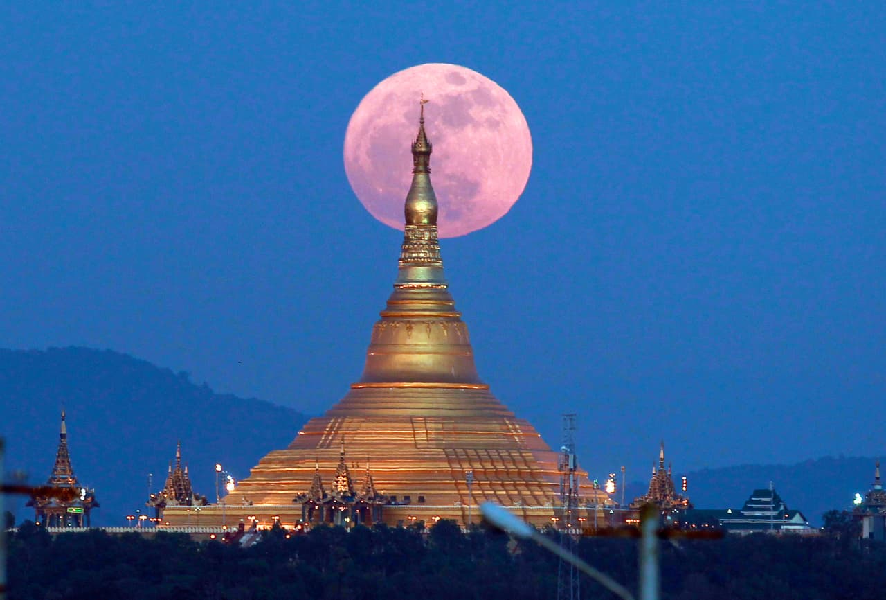 La superluna con tonos rosados al atarceder, detrás la pagoda Uppatasanti, en Naypyitaw, Myannmar.