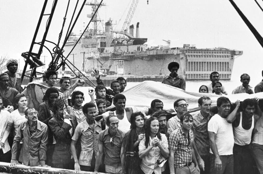 En esta foto de archivo de mayo de 1980, refugiados cubanos en la cubierta de su barco a su llegada a la lluviosa Key West, Florida.