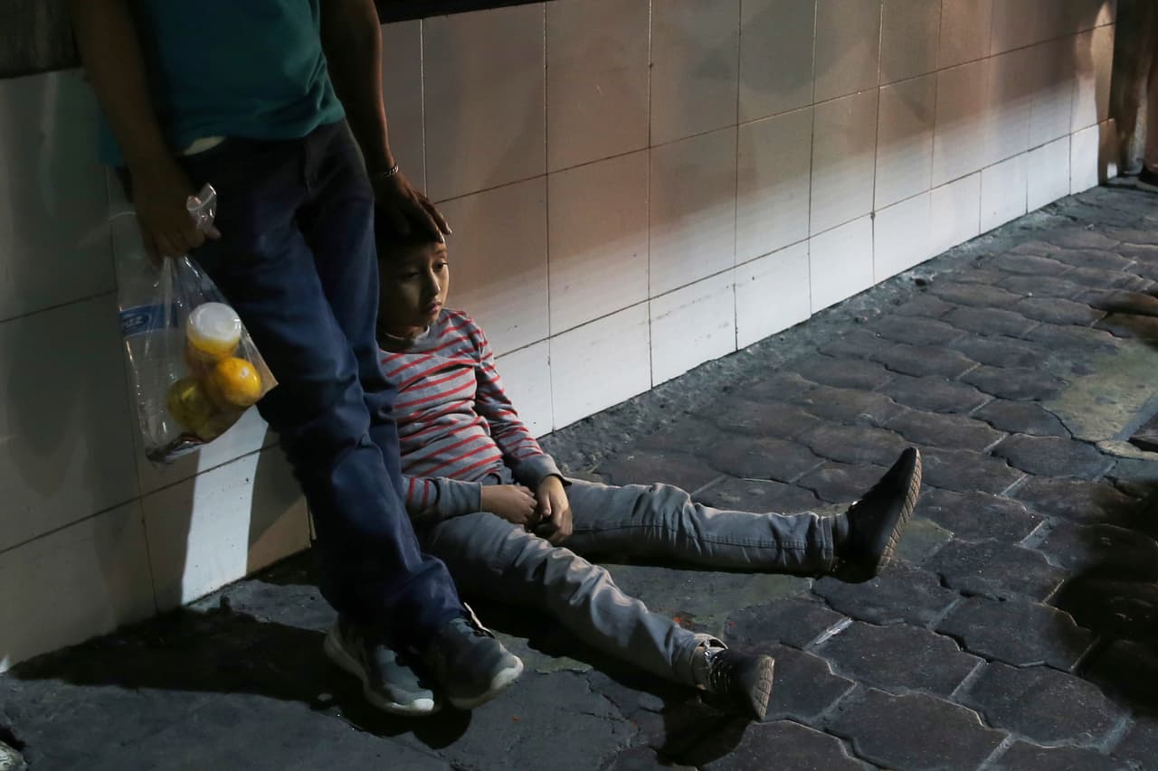 En esta foto del 18 de julio de 2019, un niño migrante y su padre permanecen juntos después de ser transportados por las autoridades migratorias mexicanas desde Nuevo Laredo a Monterrey, México.