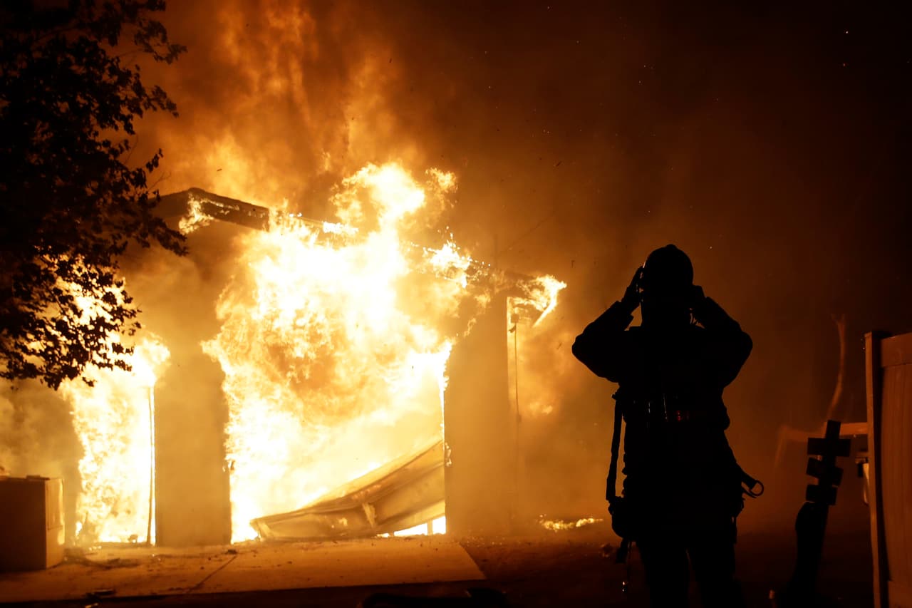 Un bombero se prepara para combatir las llamas que han acabado con una vivienda en Santa Clarita.