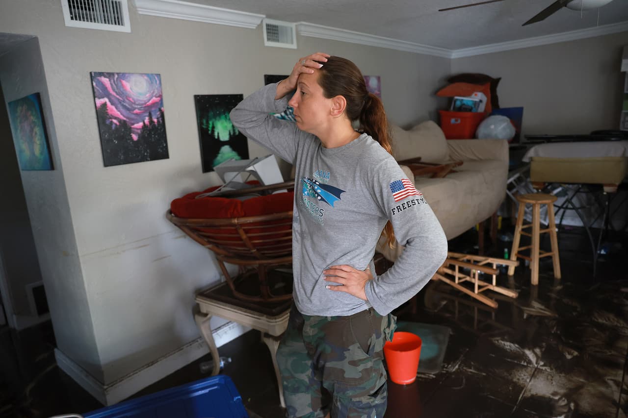 Stefanie Karas entra a su apartamento después de que el agua empujada por el huracán Ian lo inundara. Karas vive en Fort Myers y es artista y esta mañana estaba tratando de rescatar objetos del desastre que quedó en su casa. 
<br>
<br>