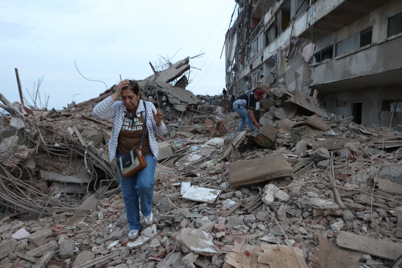 Residentes caminan entre los escombros de edificios dañados por un terremoto en Catia La Mar, Venezuela, el jueves 25 de junio de 2026.