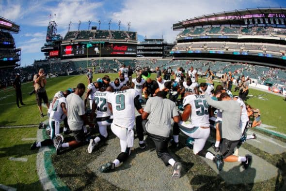 Los jugadores de los Eagles de Filadelfia y los Jacksonville Jaguars se arrodillan para orar en la línea de 50 yardas después de que los Eagles derrotaron a los Jaguars por 34-17 en un partido en el Lincoln Financial Field el 7 de septiembre de 2014 en Philadelphia, Pennsylvania.