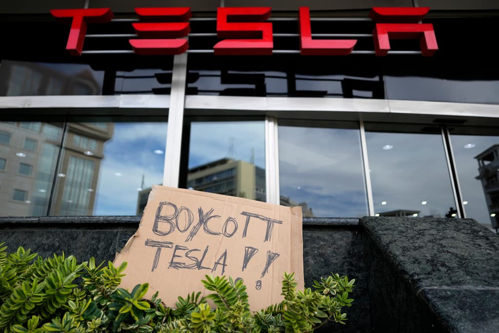 Una pancarta fue desplegada afuera de un showroom de Tesla durante una manifestación en Lisboa, el domingo 9 de marzo de 2025. (AP Foto/Armando Franca)