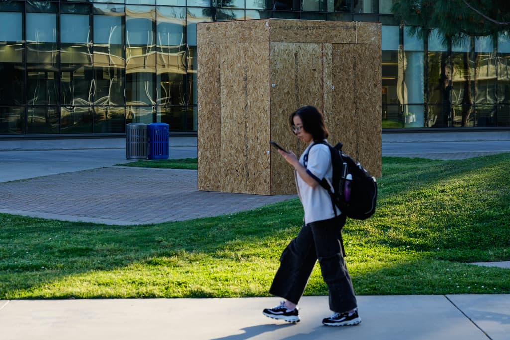 Un estudiante pasa junto a una estatua de César Chávez que ha sido cubierta con madera contrachapada en la Universidad Estatal de California en Fresno, en Fresno, California, el miércoles 18 de marzo de 2026.
