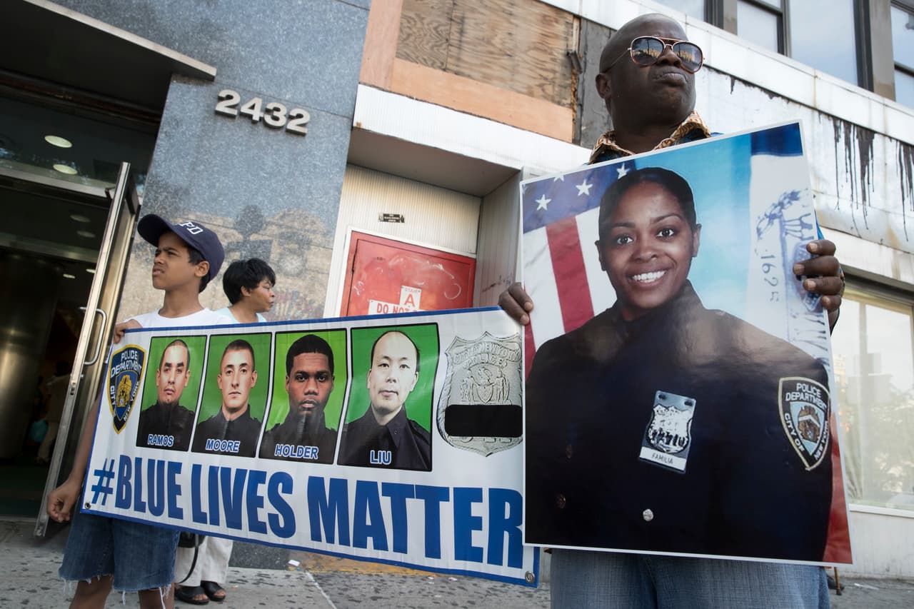 "Un día como hoy hace 12 años mi madre se unió al NYPD", dijo su hija mayor, Génesis, junto a sus dos hermanos. "Cuando era pequeña estaba tan orgullosa de que mi mamá era una policía", contó a los presentes flanqueada por una enorme foto de su madre. (Mary Altaffer/AP)