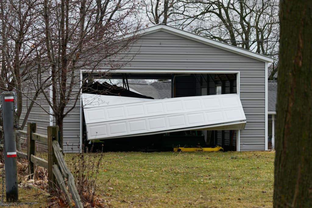 Una puerta de garaje dañada por la tormenta yacía doblada un día después de que una tormenta que provocó un tornado azotara la zona, en Union City, Michigan, el sábado 7 de marzo de 2026.