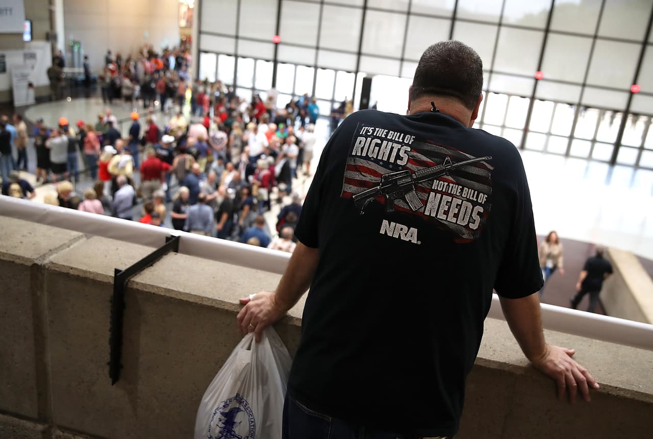 Un hombre mira la larga fila para entrar al centro de convenciones de Dallas. El presidente Donald Trump se presentó ante los miembros de la NRA en su convención por cuarto año consecutivo.
