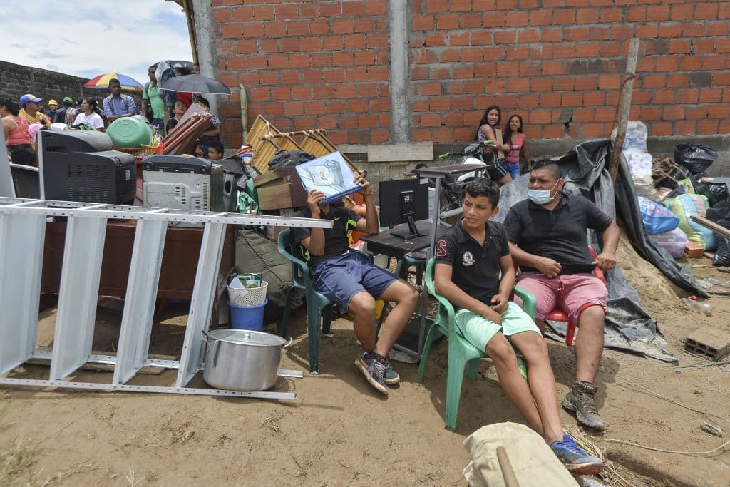 Familias en la región afectada al sur de Colombia, se sientan junto a las pertenecias que pudieron salvar.