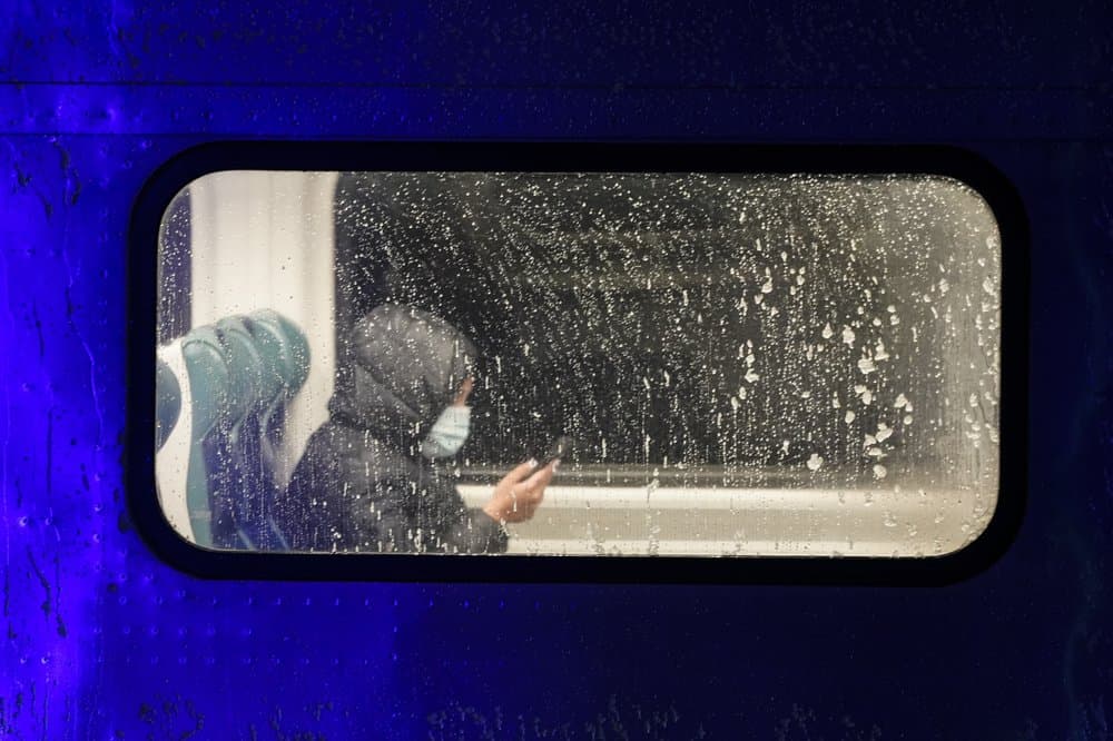 Un pasajero revisa su celular mientras viaja en un vagón de tren de Long Island Rail Road, cuando empieza a nevar en Queens, Nueva York.