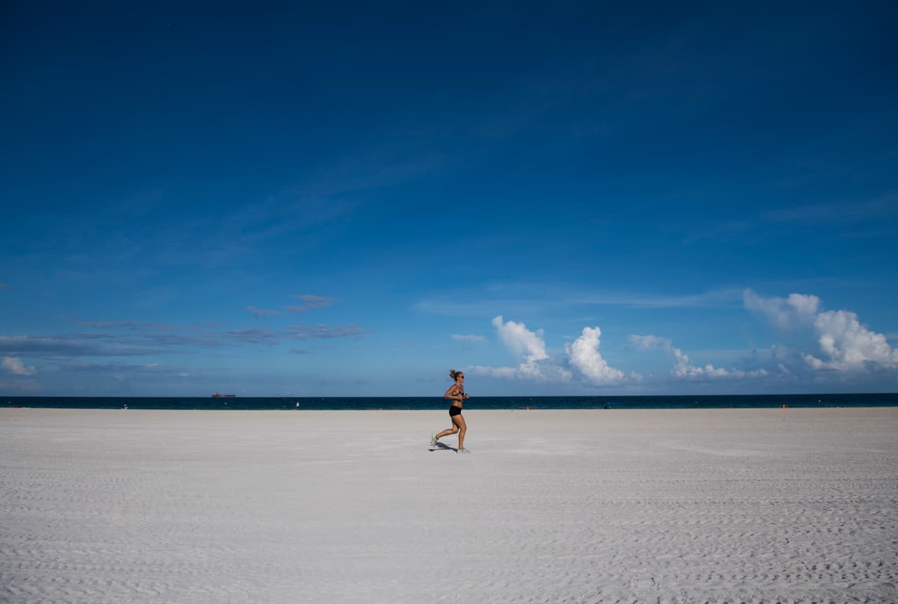 Una mujer corre en South Beach, una playa casi desierta en Miami Beach, Florida.