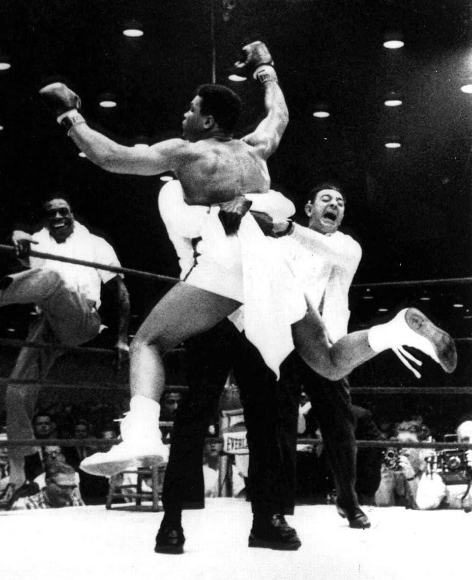 In this Feb. 25, 1964, file photo, new heavyweight boxing champion Cassius Clay is lifted off the ring floor in Miami Beach by one of his handlers after defeating Sonny Liston. Another Clay handler, left, climbs through the ropes as trainer Angelo Dundee, right, reacts.
