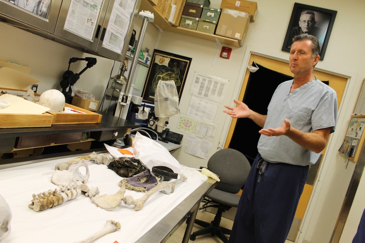 El Doctor Bruce Anderson, de la oficina del Médico Forense del condado Pima, explica el proceso para tomar la muestra de ADN de los restos humanos.