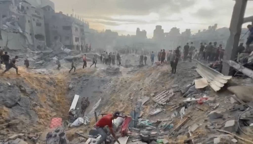 Esta imagen tomada de un video de AFPTV muestra a palestinos buscando sobrevivientes en un cráter luego de un ataque en un campo de refugiados en Jabalia, en el norte de la Franja de Gaza, el 31 de octubre de 2023, en medio de un implacable bombardeo israelí del territorio palestino.