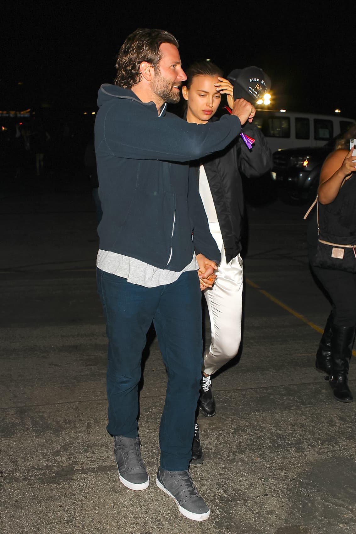 Muy caballeroso, Bradley intentó proteger a su novia con su gorra.