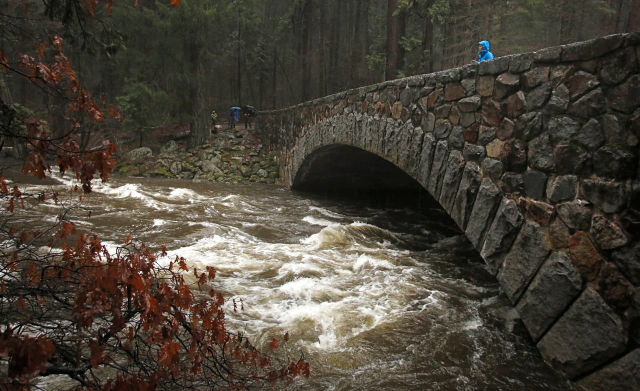 Un visitante en Yosemite observa el crecido caudal del río Merced desde el puente Pohono antes del cierre del parque.