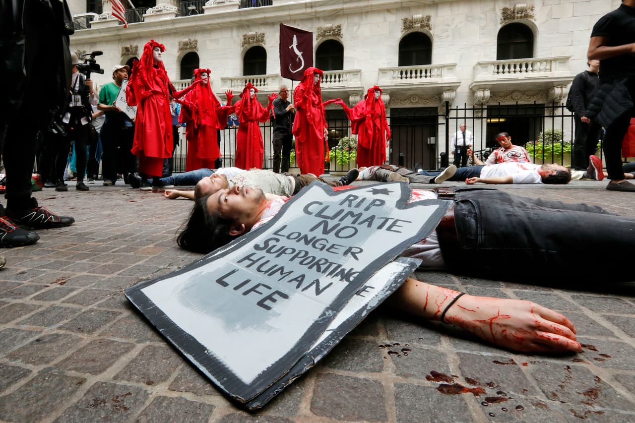 Manifestantes se acostaron en charcos de sangre falsa frente a la Bolsa de Valores de Nueva York para concientizar sobre las personas que han muerto a causa de enfermedades y desastres relacionados con el cambio climático.