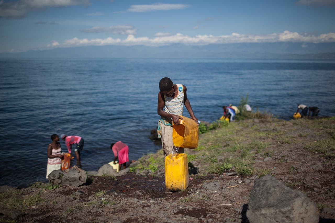 Una mujer joven llena un bidón en el lago Kivu, en la República Democrática del Congo. A esta orilla se le conoce irónicamente como el Cólera Beach debido a la contaminación. Los residentes de la comunidad de Goma se ven obligados a beber agua del lago debido a la falta de agua corriente limpia disponible. FEDERICO SCOPPA / AFP / Getty Images