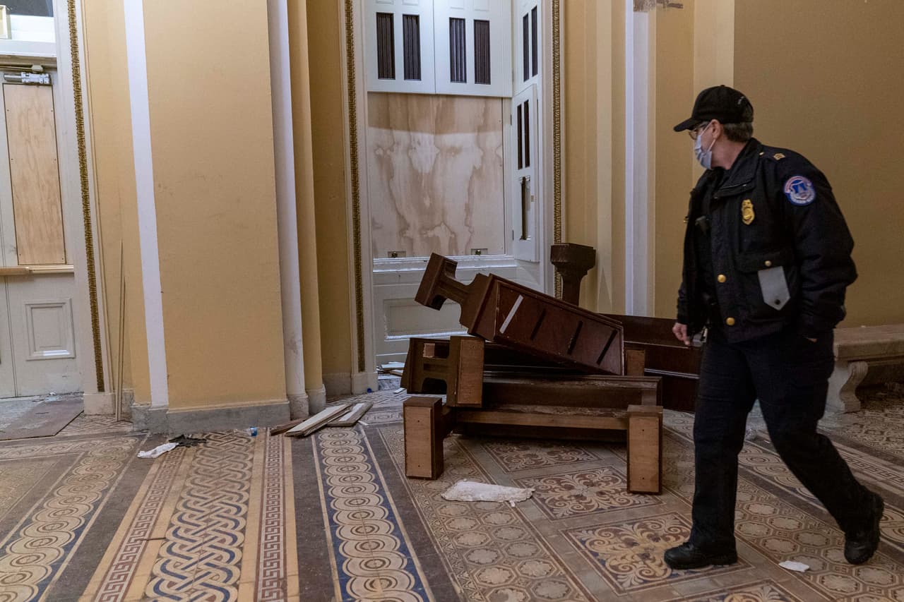 Los restos en el suelo del marco de una dañada por la turba. Al lado había una pila de muebles estropeados por los invasores.
<br>