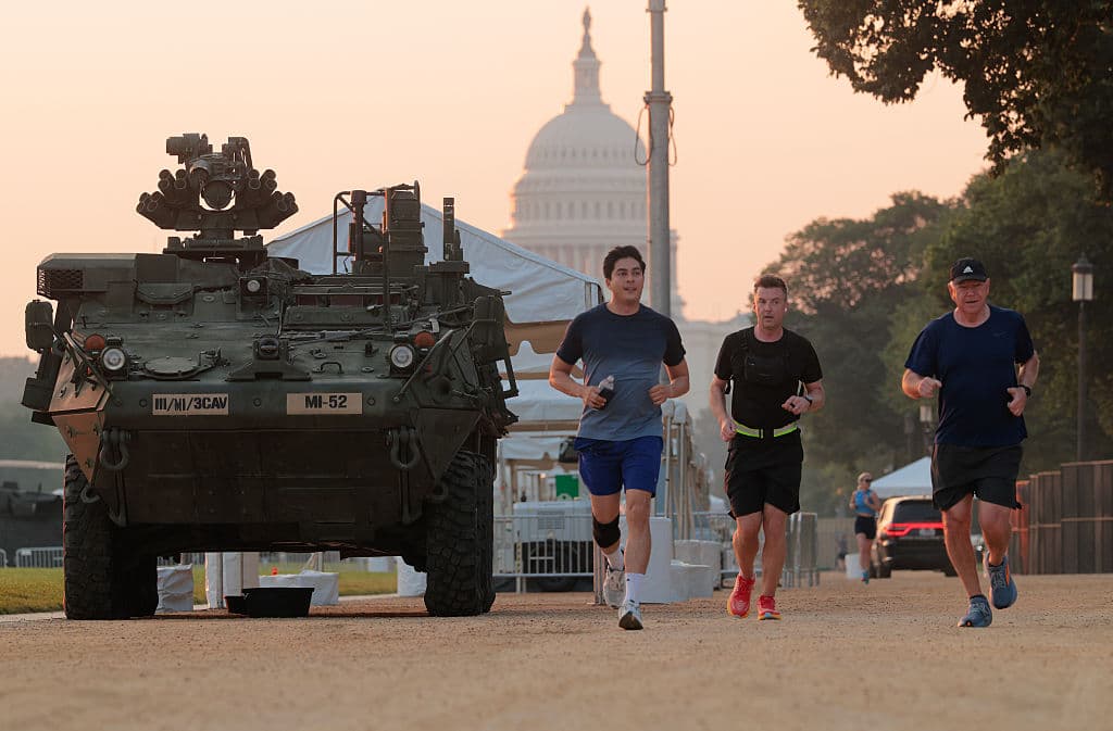 El gobernador de Minnesota, Tim Walz, pasa corriendo junto a un vehículo de combate Stryker del Ejército, en el National Mall, antes del desfile militar y la celebración de este fin de semana en Washington DC. El Ejército celebrará su 250º aniversario el sábado, que coincide con el cumpleaños del presidente Donald Trump.
