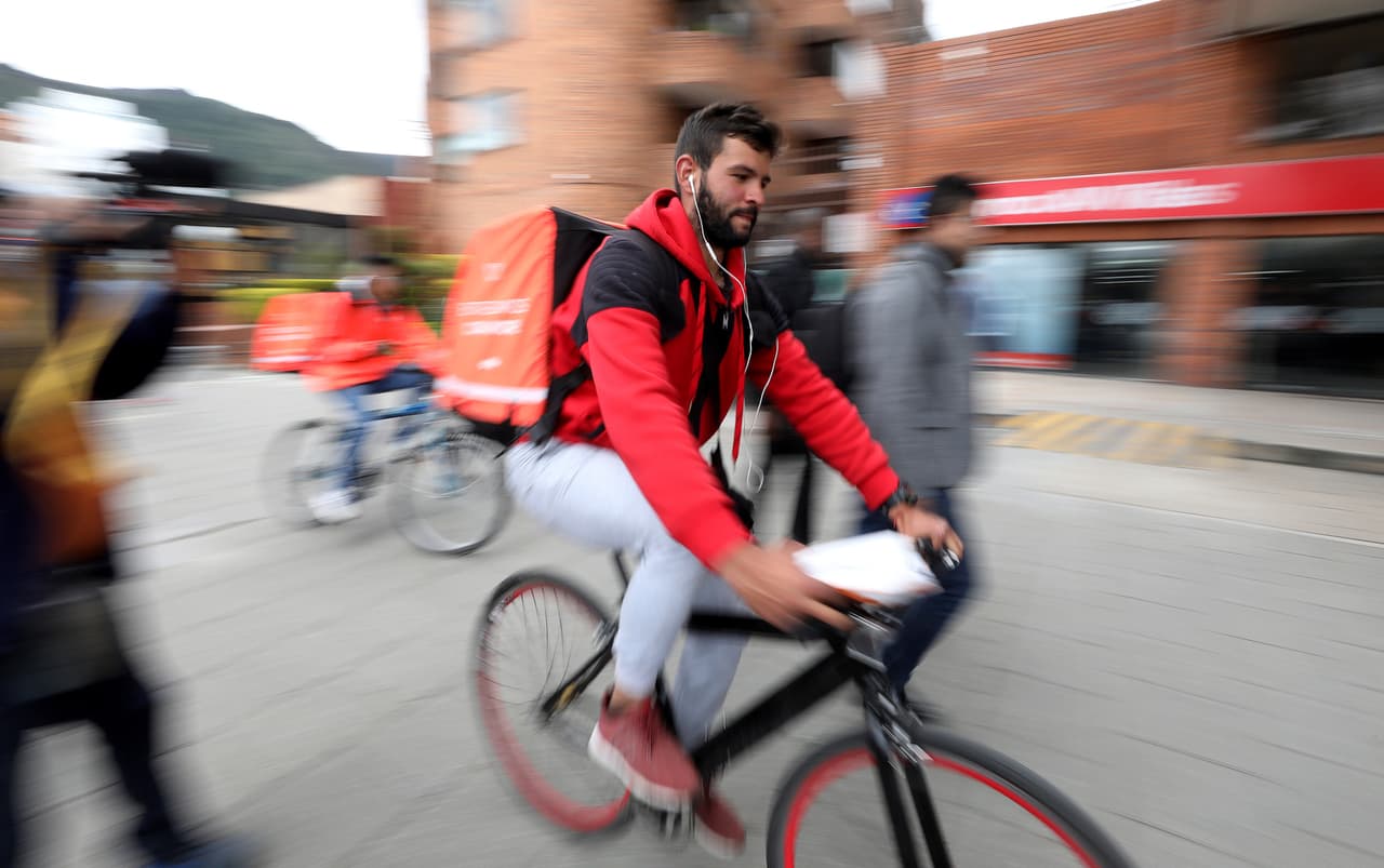 Samuel Romero, un inmigrante venezolano de 21 años, lleva una orden de entrega de la aplicación Rappi en Bogotá, Colombia, donde vive desde el año pasado. Este sistema, que se ha expandido a ocho países latinoamericanos desde que fue fundado hace cuatro años, conecta a través del teléfono a un ciclista con un cliente para que le lleve casi cualquier cosa, desde comida china hasta una caja de pañales. Para Romero esta entrega es el comienzo de una jornada laboral de 15 horas, en donde ganará el equivalente a 15 dólares.