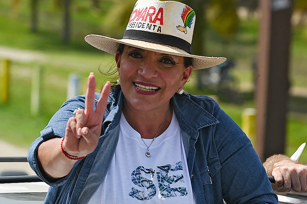 La candidata presidencial hondureña por el principal partido de oposición de izquierda, Libertad y Refundación (LIBRE), Xiomara Castro, esposa del derrocado ex presidente Manuel Zelaya, muestra el signo de la victoria mientras hace campaña en Tela, en la costa atlántica hondureña, el 31 de octubre de 2021.