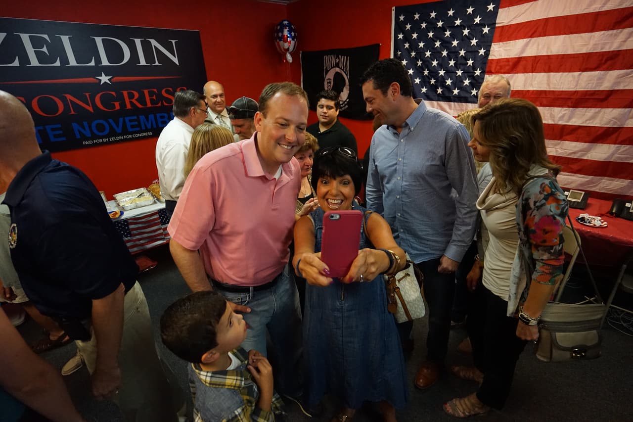 El congresista Lee Zeldin posando para una foto con una votante en la oficina de campaña de Shirley.