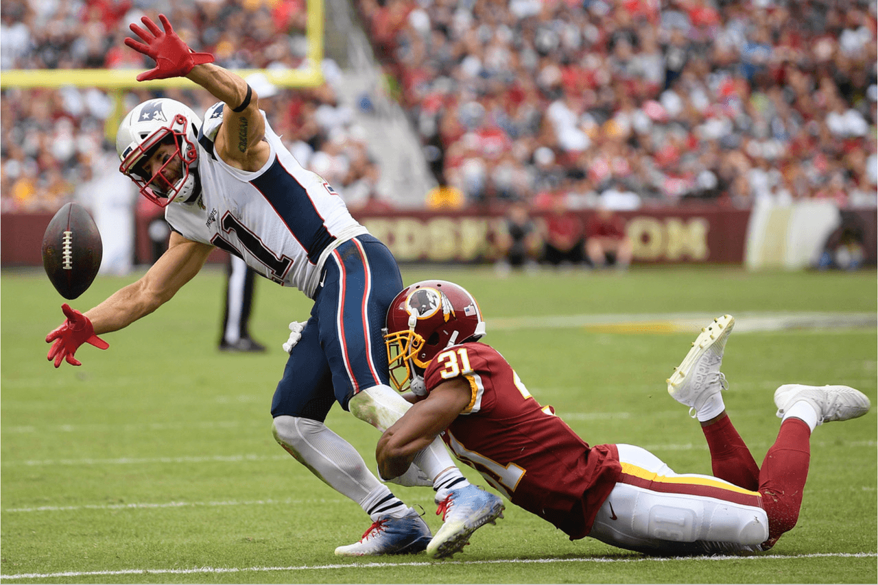 El receptor de los New England Patriots, Julian Edelman pierde el ovoide ante Fabian Moreau de los Washington Redskins.
