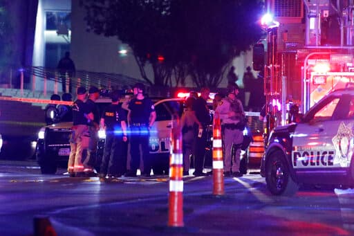 Personal médico y policial en uno de los sitios donde resultó herido de bala un agente, cerca de una corte federal.
