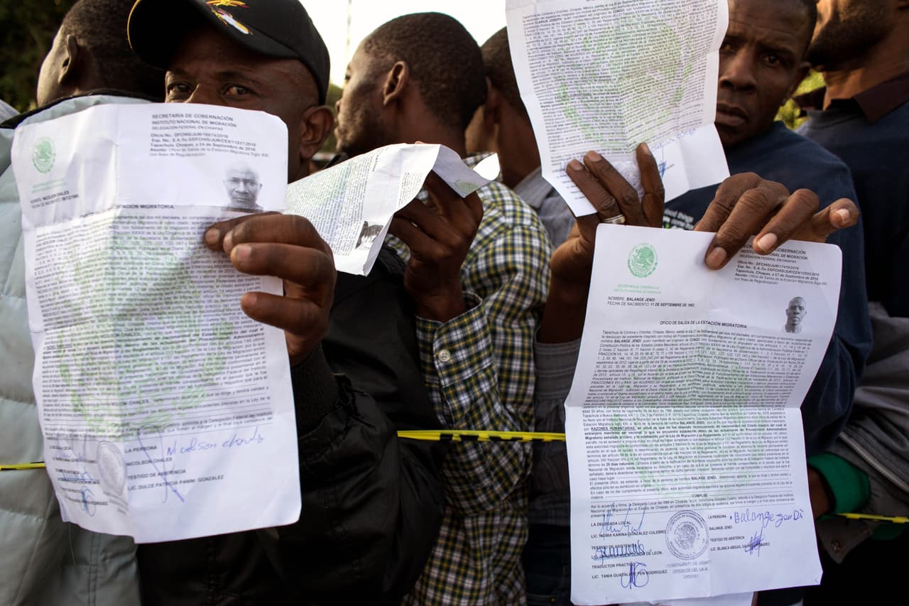 Haitianos muestran sus documentos mientras hacen fila para solicitar asilo en fuera de la oficina de migración de México, en Tijuana. Octubre 2016.