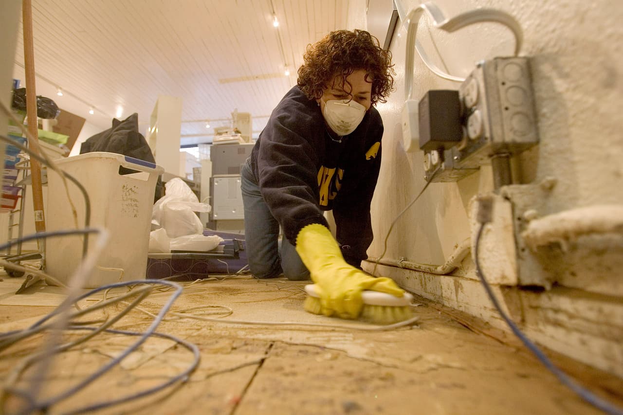SAN ANSELMO, CA - JANUARY 2: Johanna Sedman cleans up her store, PS Paper, after a flood waters receded January 2, 2006 in San Anselmo, California. Northern California has been inundated by heavy rain over the past week, causing mudslides and pushing rivers over their banks. (Photo by David Paul Morris/Getty Images)
