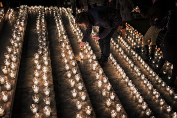 Una mujer enciende una vela durante una reunión en Lyon , en el centro -este de Francia .